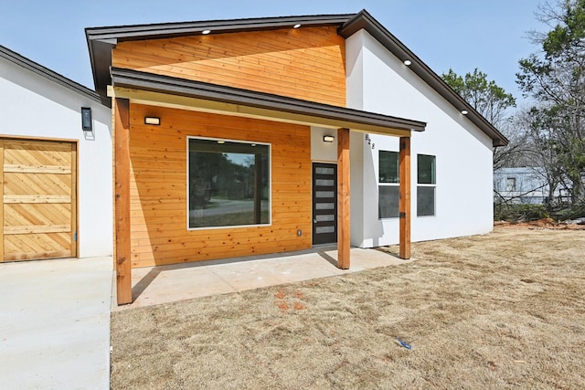 back of property featuring stucco siding