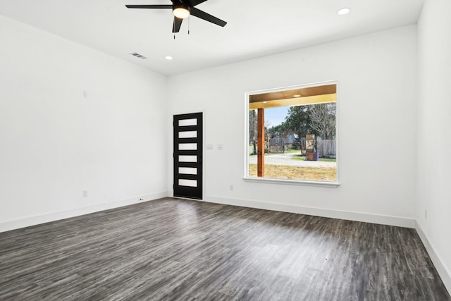 unfurnished room with baseboards, dark wood finished floors, and recessed lighting