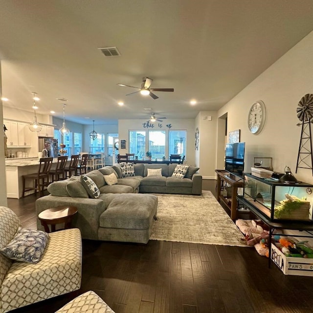 living room with ceiling fan, dark wood-style flooring, and visible vents