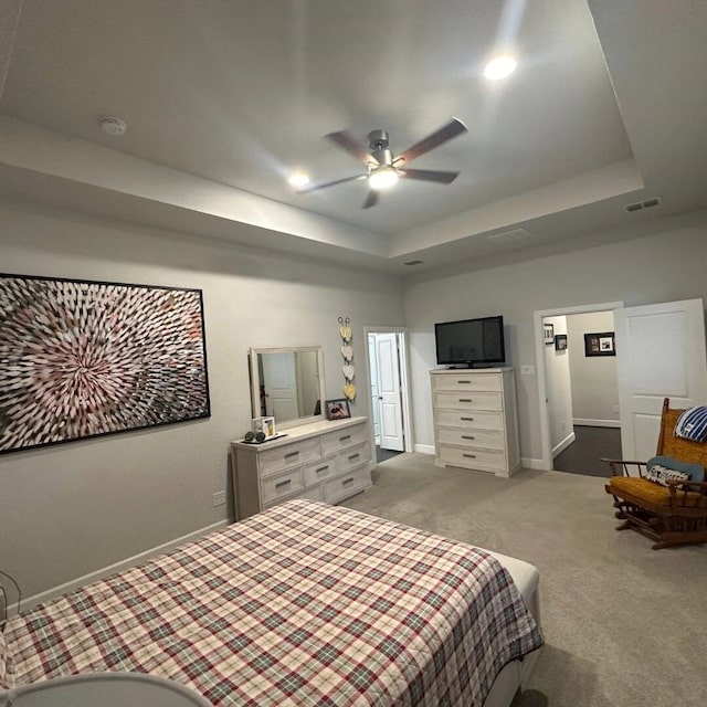 bedroom featuring carpet, visible vents, a tray ceiling, and baseboards