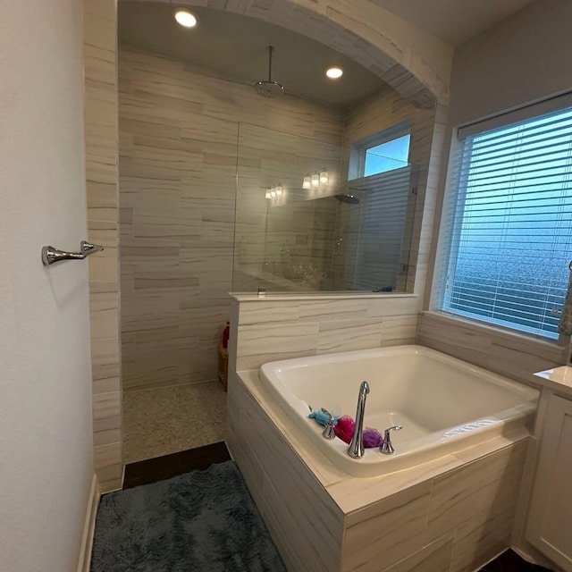 bathroom with a walk in shower and a garden tub