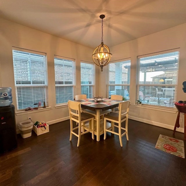 dining area with an inviting chandelier, baseboards, and dark wood-style flooring