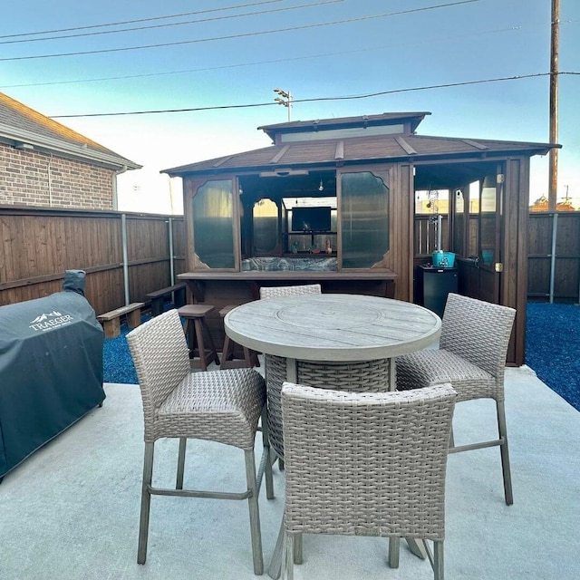 view of patio with outdoor dining space, grilling area, and a fenced backyard