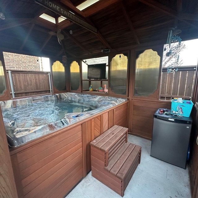 view of patio / terrace featuring fence and a hot tub