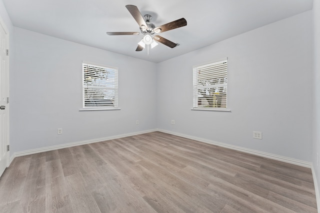 empty room with baseboards, a ceiling fan, and light wood-style floors