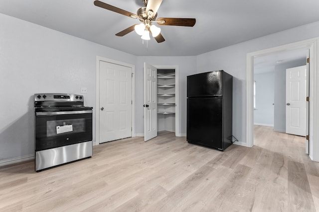 kitchen with light wood finished floors, baseboards, a ceiling fan, electric stove, and freestanding refrigerator