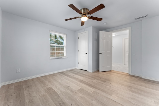 unfurnished bedroom with a ceiling fan, visible vents, light wood-style flooring, and baseboards