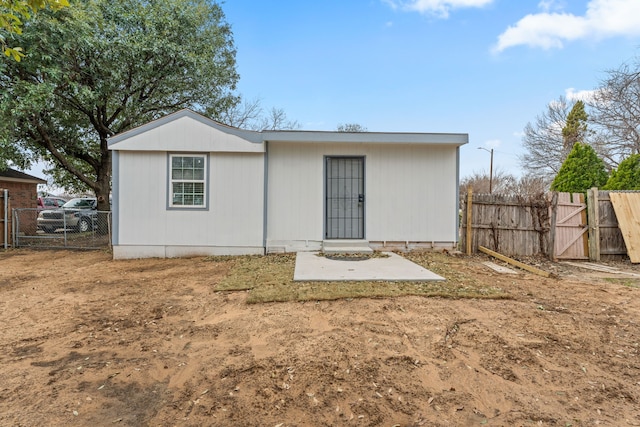 back of property with a gate and fence