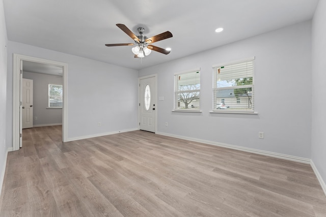 foyer entrance with plenty of natural light, light wood-style flooring, and baseboards