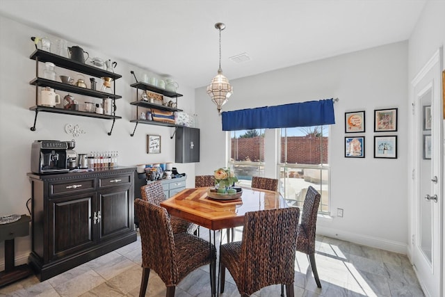 dining area featuring a notable chandelier, baseboards, and visible vents