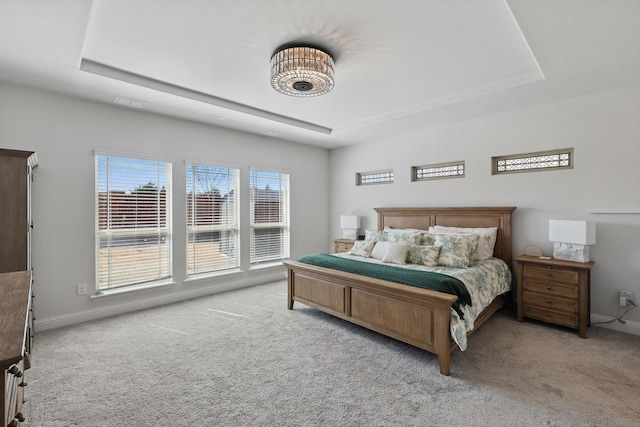 carpeted bedroom featuring baseboards, a raised ceiling, and visible vents