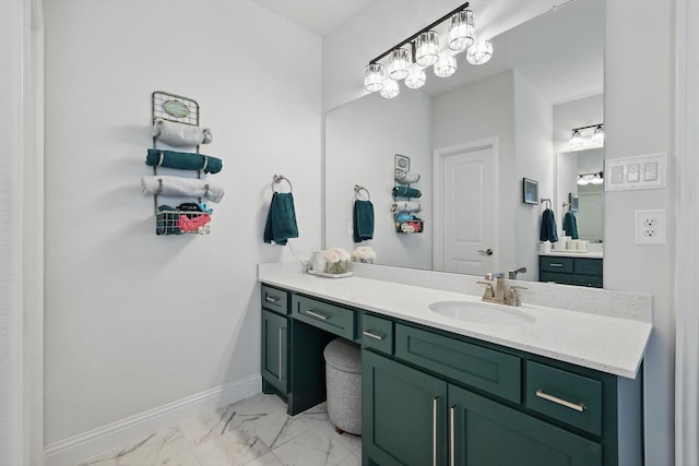 bathroom with marble finish floor, vanity, and baseboards