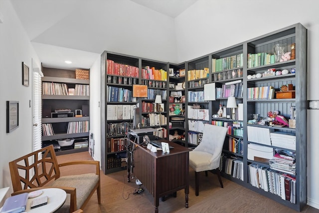 office area with wood finished floors and wall of books