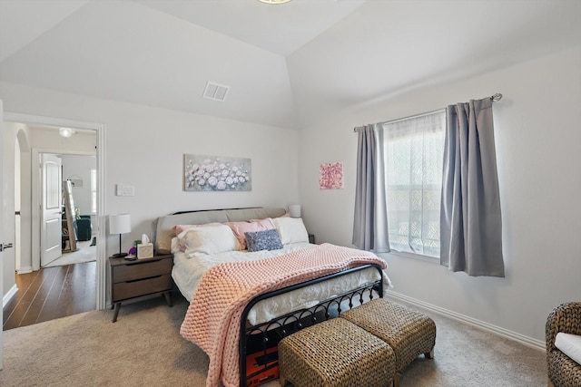 carpeted bedroom featuring vaulted ceiling, multiple windows, baseboards, and arched walkways