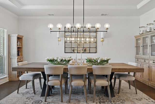 dining space featuring a tray ceiling, dark wood-style floors, visible vents, and ornamental molding