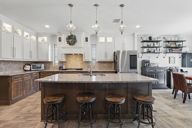 1608 Nighthawk Ln, Mansfield, TX 76063 - kitchen featuring smart refrigerator, a sink, a kitchen bar, white cabinets, and a center island with sink