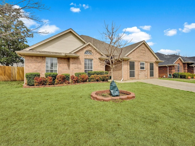 ranch-style home featuring brick siding, fence, driveway, and a front lawn