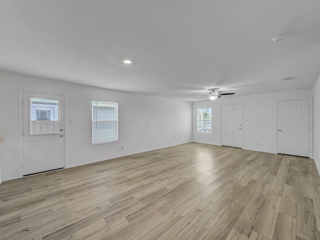 unfurnished living room with ceiling fan, visible vents, light wood-style flooring, and baseboards