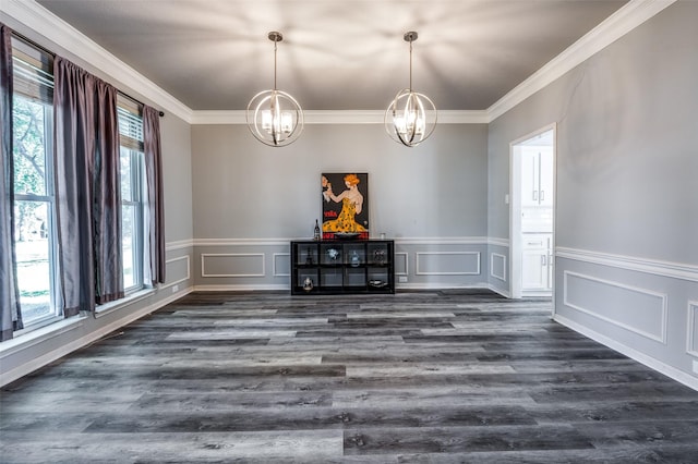 unfurnished dining area with dark wood-type flooring, a chandelier, ornamental molding, and a decorative wall