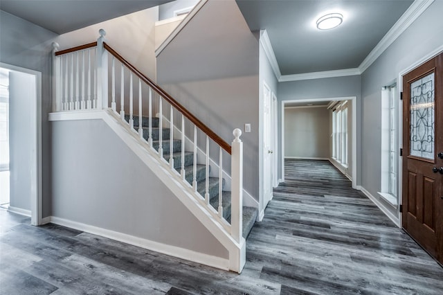 foyer entrance featuring baseboards, stairway, wood finished floors, and crown molding