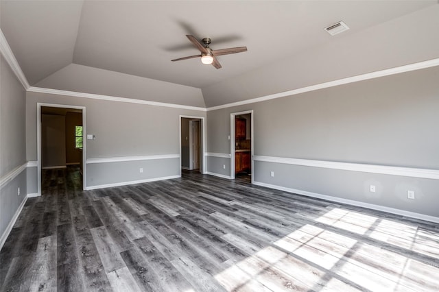 unfurnished room featuring vaulted ceiling, ornamental molding, dark wood-style floors, and visible vents