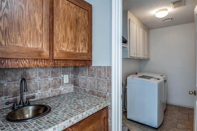 laundry room featuring visible vents, laundry area, a sink, and washer / dryer