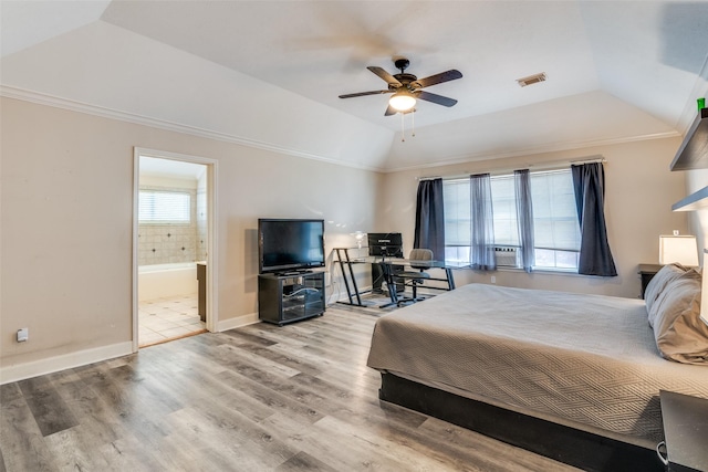 bedroom featuring visible vents, baseboards, vaulted ceiling, light wood-type flooring, and crown molding