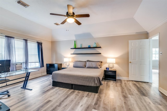 bedroom with lofted ceiling, visible vents, crown molding, and wood finished floors