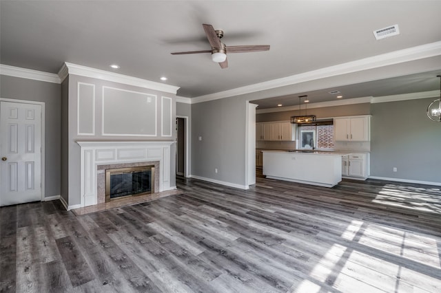 unfurnished living room with dark wood-style floors, a high end fireplace, visible vents, and baseboards