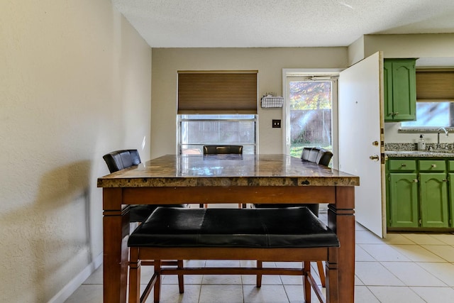 interior space featuring green cabinets, a textured ceiling, and a healthy amount of sunlight