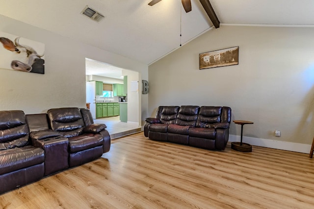 living area featuring baseboards, visible vents, lofted ceiling with beams, and light wood finished floors