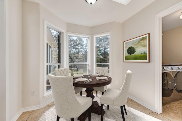 dining room with light tile patterned floors, washing machine and dryer, and baseboards