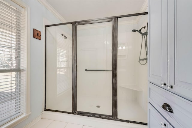 bathroom featuring ornamental molding, tile patterned flooring, and a shower stall