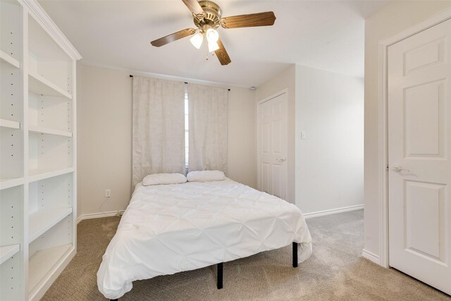 carpeted bedroom with ceiling fan and baseboards