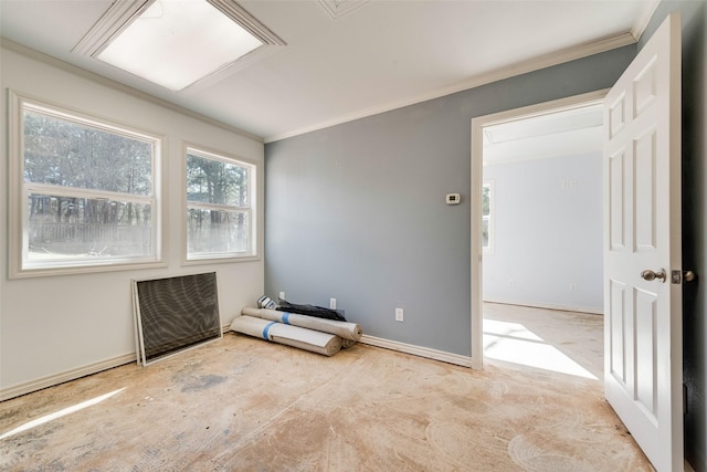 empty room featuring crown molding and baseboards