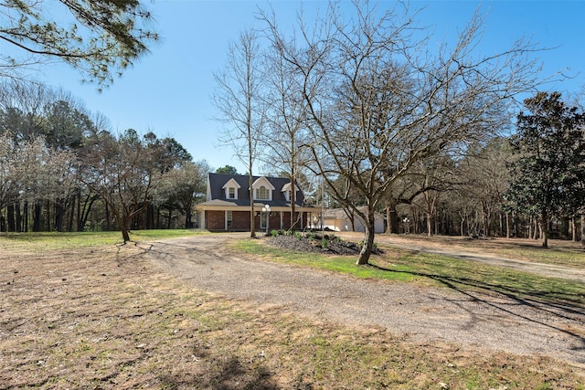 view of front of home with driveway and brick siding