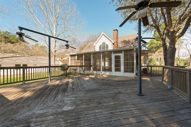 wooden terrace featuring a sunroom and a ceiling fan