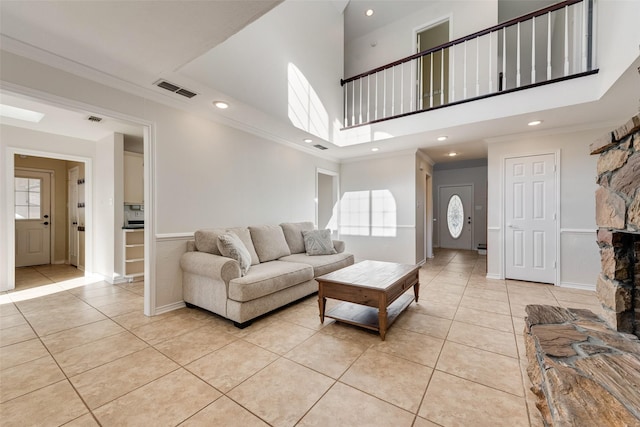 living room with light tile patterned floors, visible vents, and crown molding