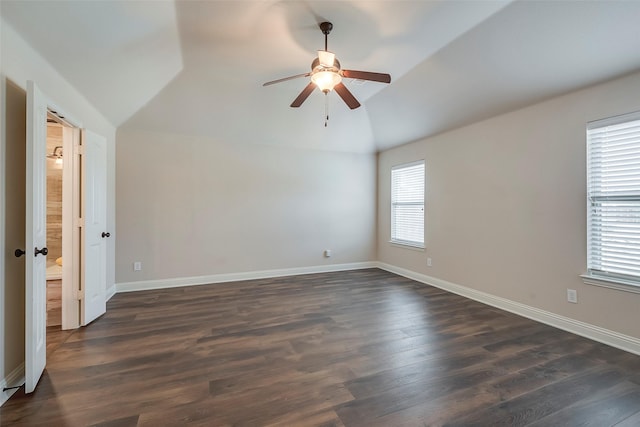 spare room with dark wood finished floors, vaulted ceiling, baseboards, and ceiling fan