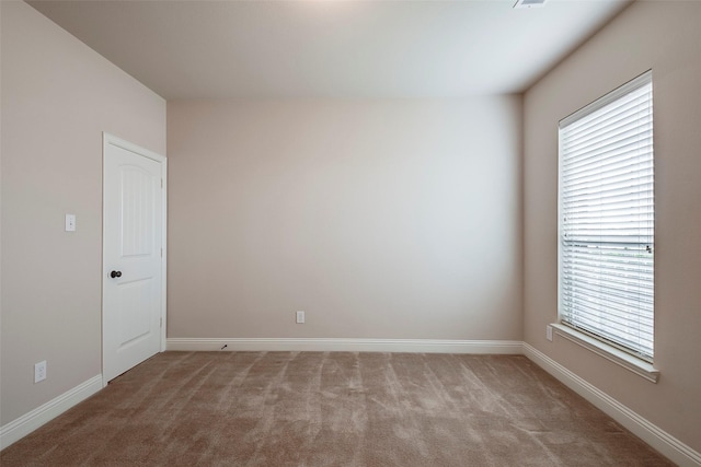 unfurnished room featuring baseboards and light colored carpet