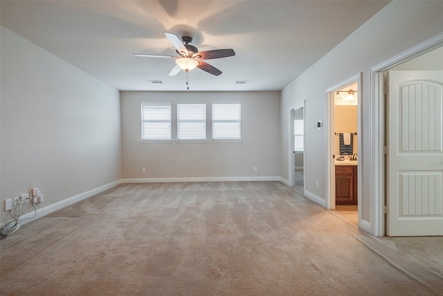 unfurnished room featuring light carpet, ceiling fan, visible vents, and baseboards