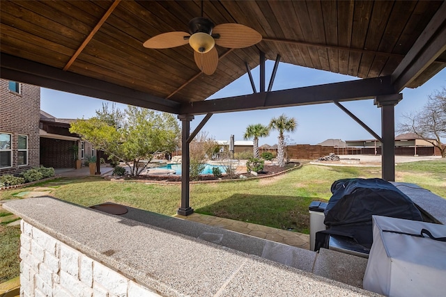 view of patio with ceiling fan, fence, a grill, and an outdoor pool