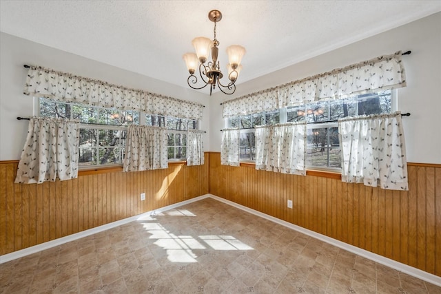 2682 Holly Trl E, Holly Lake Ranch, TX 75765 - unfurnished dining area featuring plenty of natural light, a chandelier, wooden walls, wainscoting, and baseboards