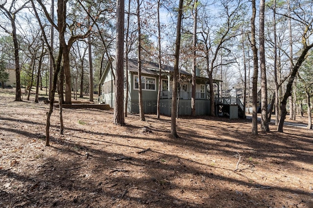 view of yard featuring covered porch and stairway