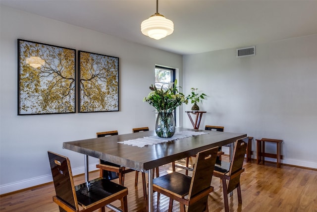 dining room with visible vents, light wood-style flooring, and baseboards