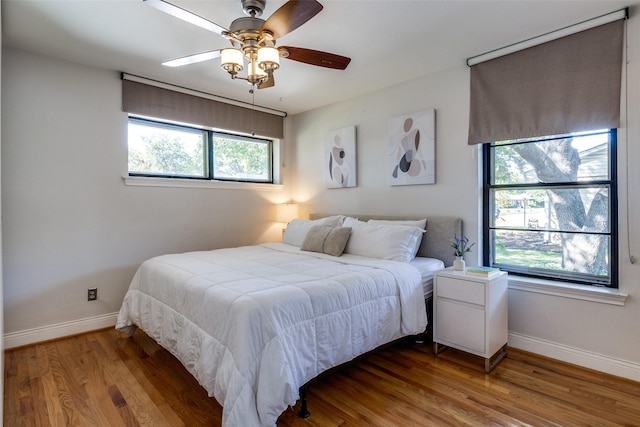 bedroom featuring a ceiling fan, baseboards, and wood finished floors