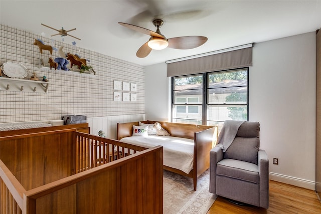 bedroom with a ceiling fan, light wood-style flooring, and baseboards