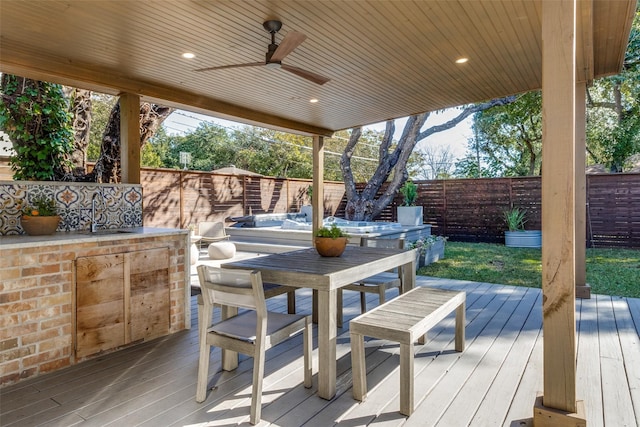 deck with a fenced backyard, a ceiling fan, a sink, and outdoor dining space