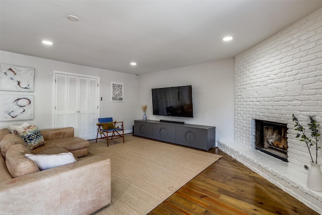 living room with baseboards, a brick fireplace, wood finished floors, and recessed lighting