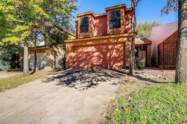 view of front of home featuring driveway, an attached garage, and brick siding